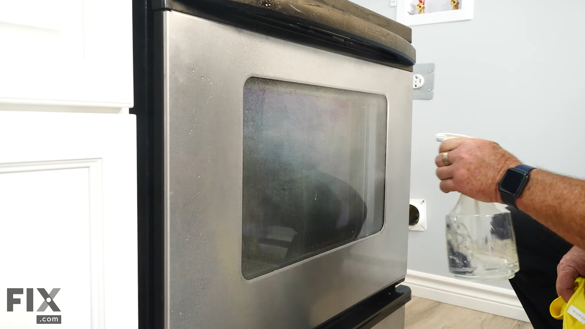 Spraying a Oven's Door with Vinegar
