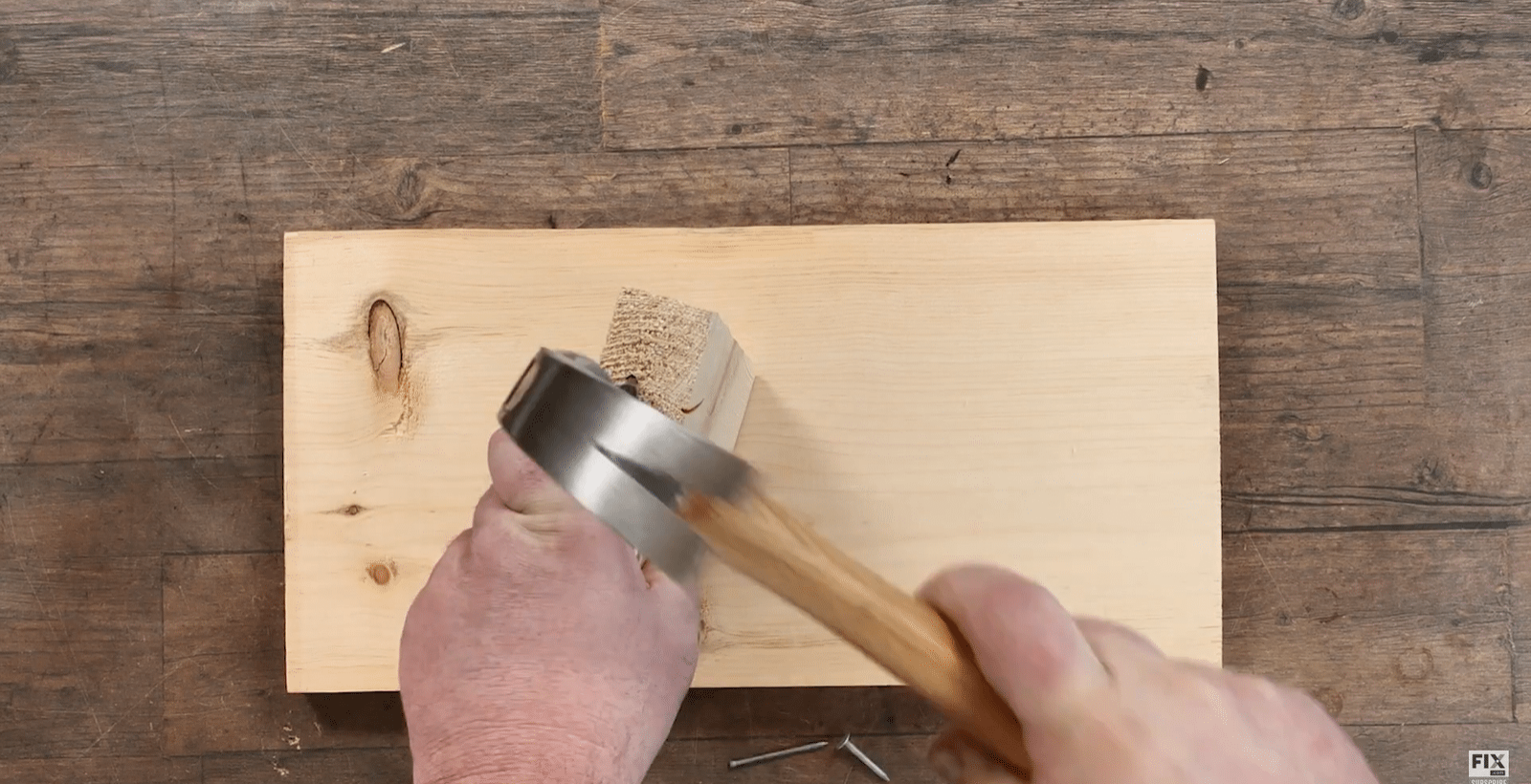 Hammering a Nail into the side of a Wooden Block