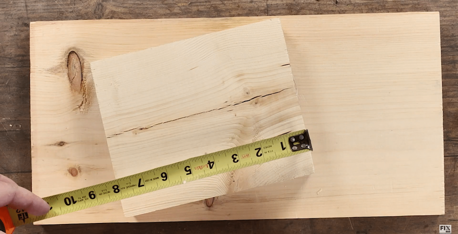 Inserting the Head of a Nail into The Slot at the End of a Measuring Tape