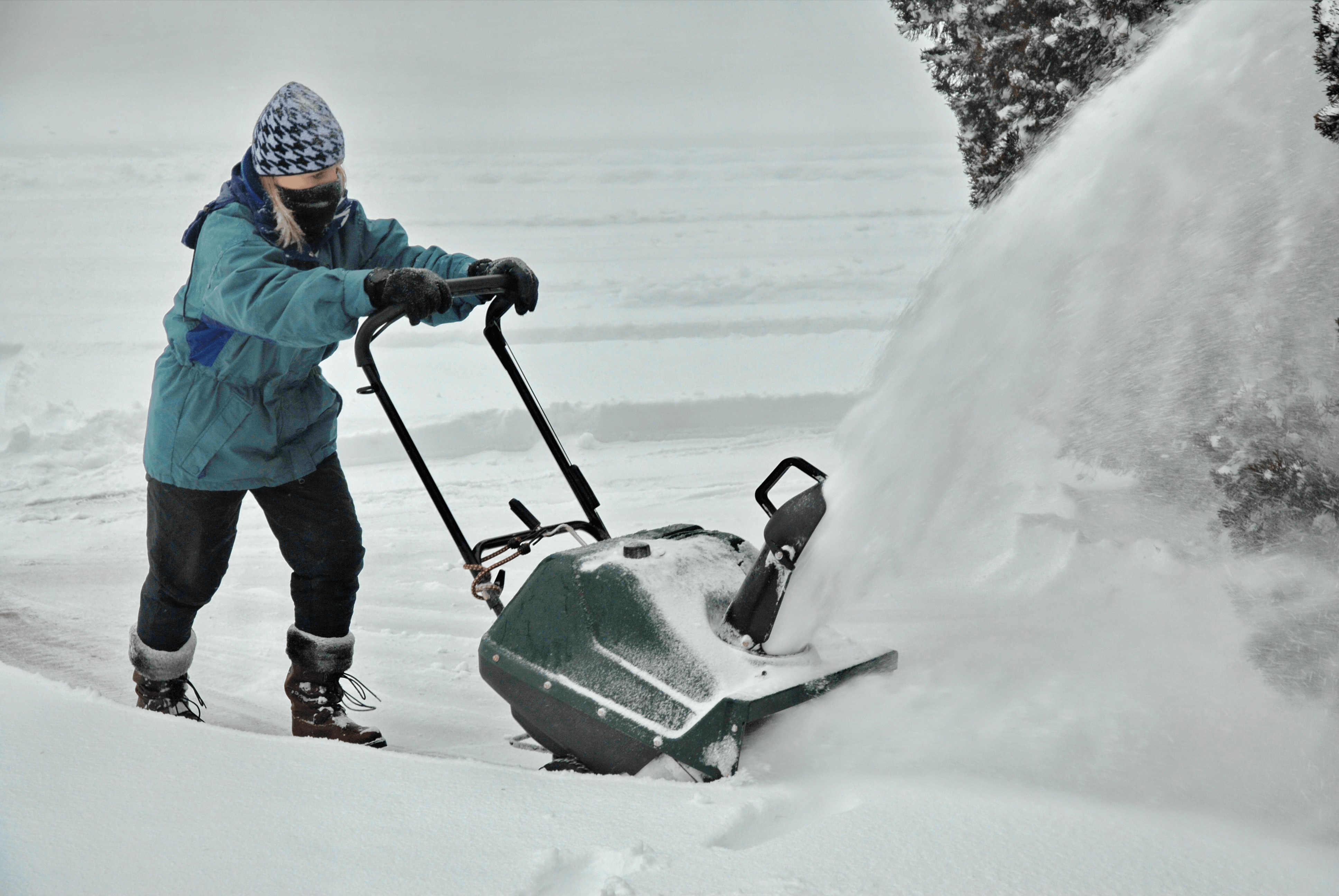 Woman Pushing a Snowblower