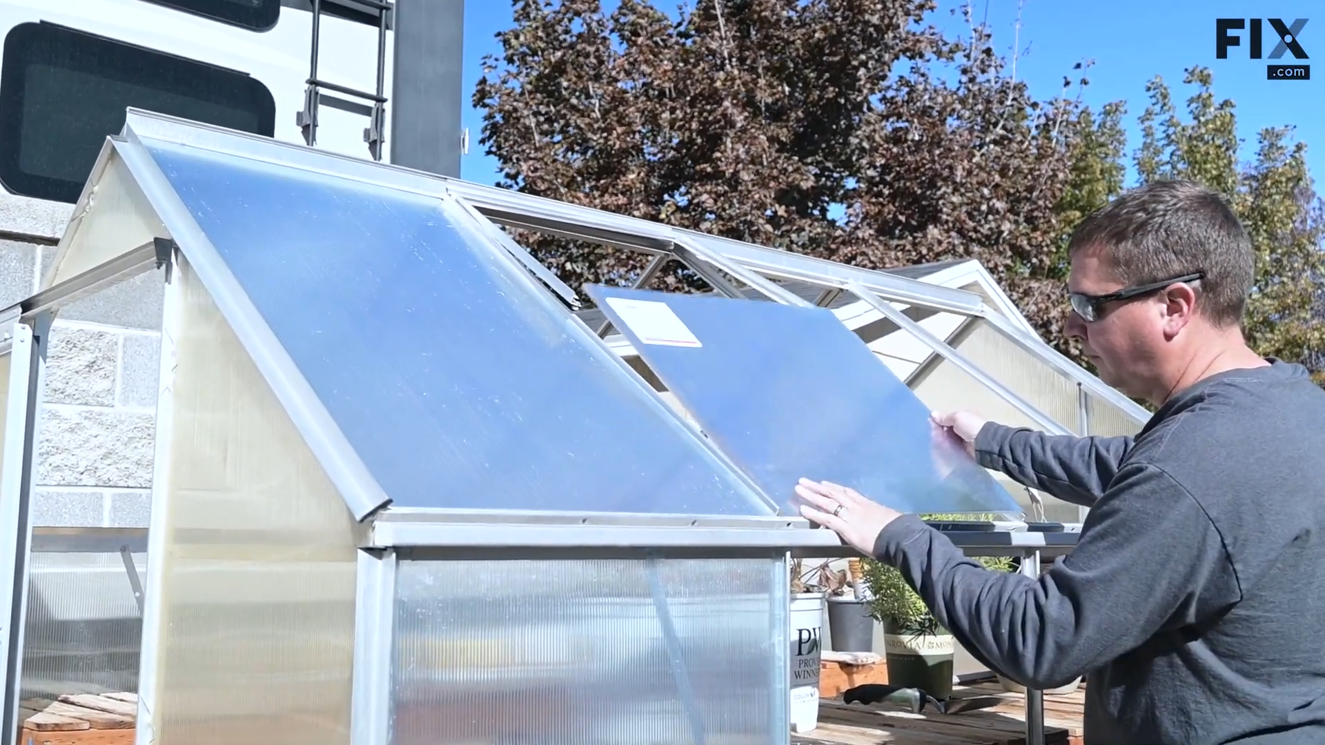 Expert technician installing the lower panel of a greenhouse vent