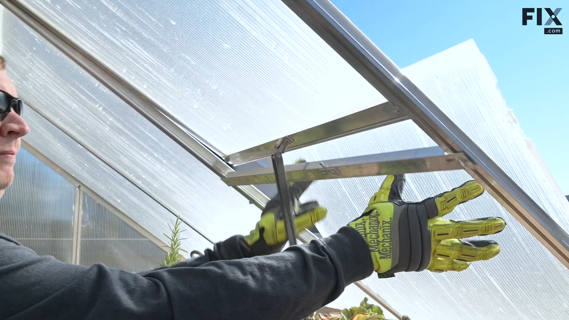 Expert technician removing the lower panel of a greenhouse vent