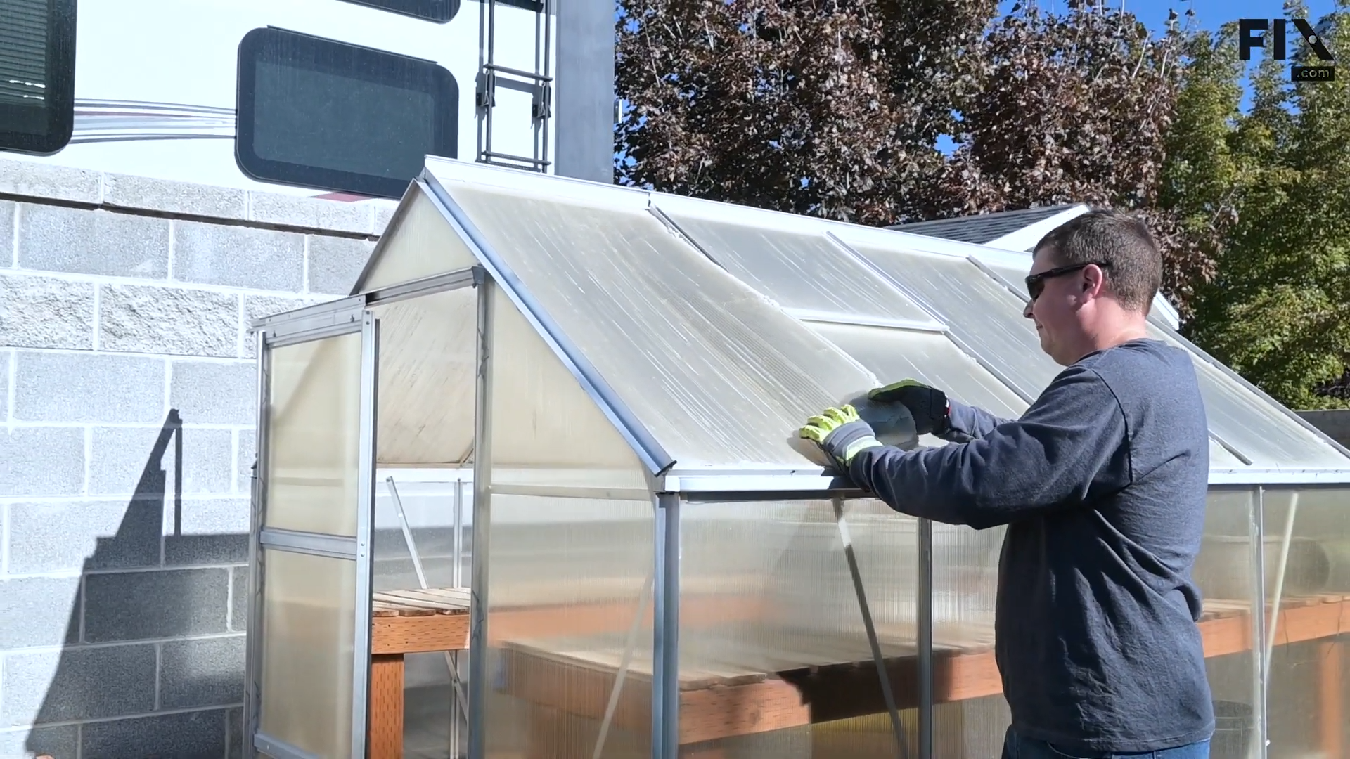 Expert technician wearing protective gloves and removing a roof panel from a greenhouse using their hands