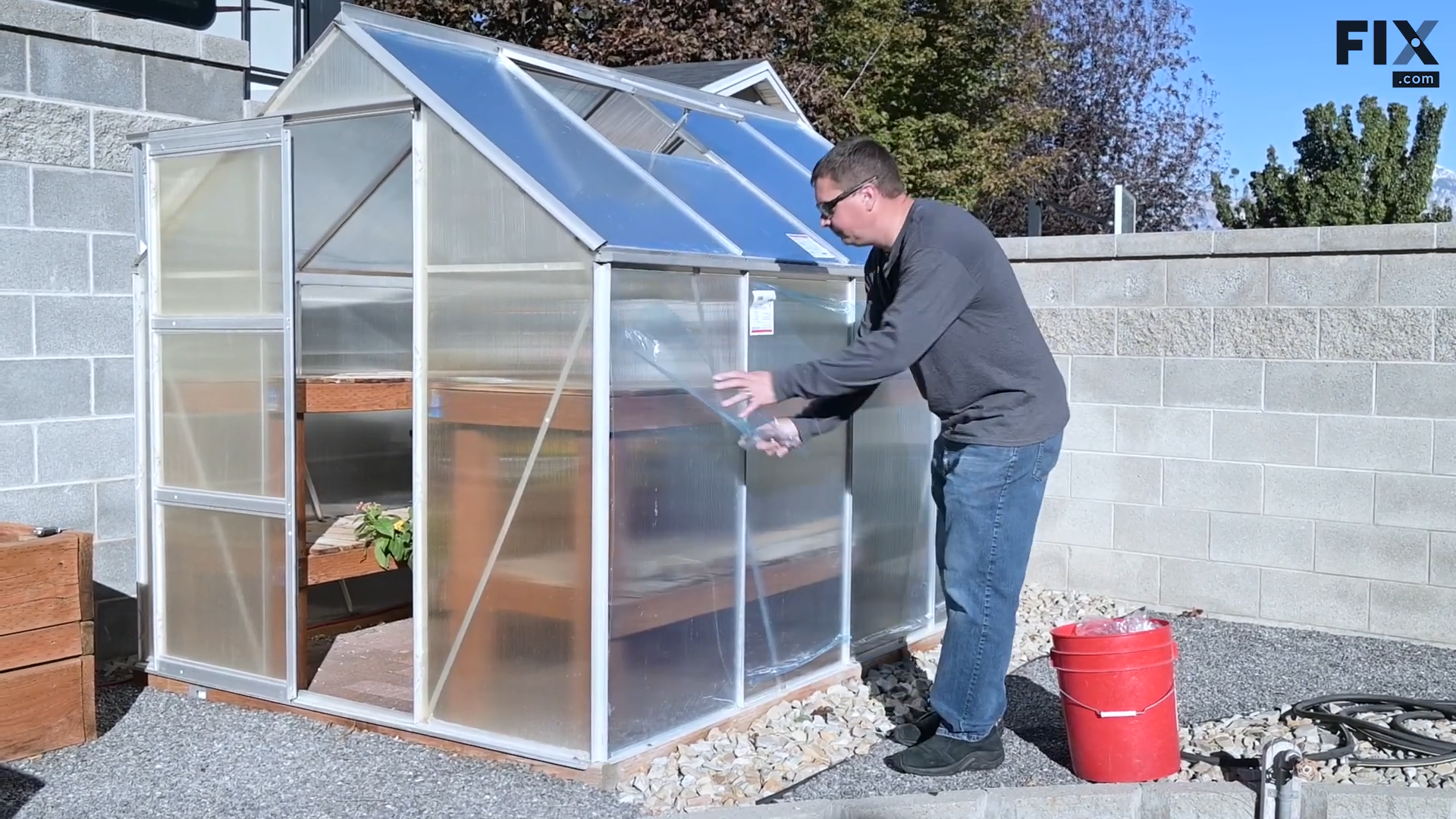 Expert technician removing the blue UV protective film on a double-wall polycarbonate greenhouse wall panel