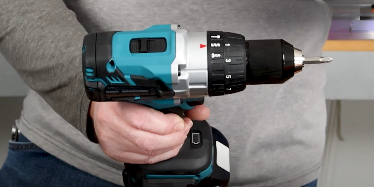 Repair technician holding a cordless drill and emphasizing the location of the selector dial and speed selector
