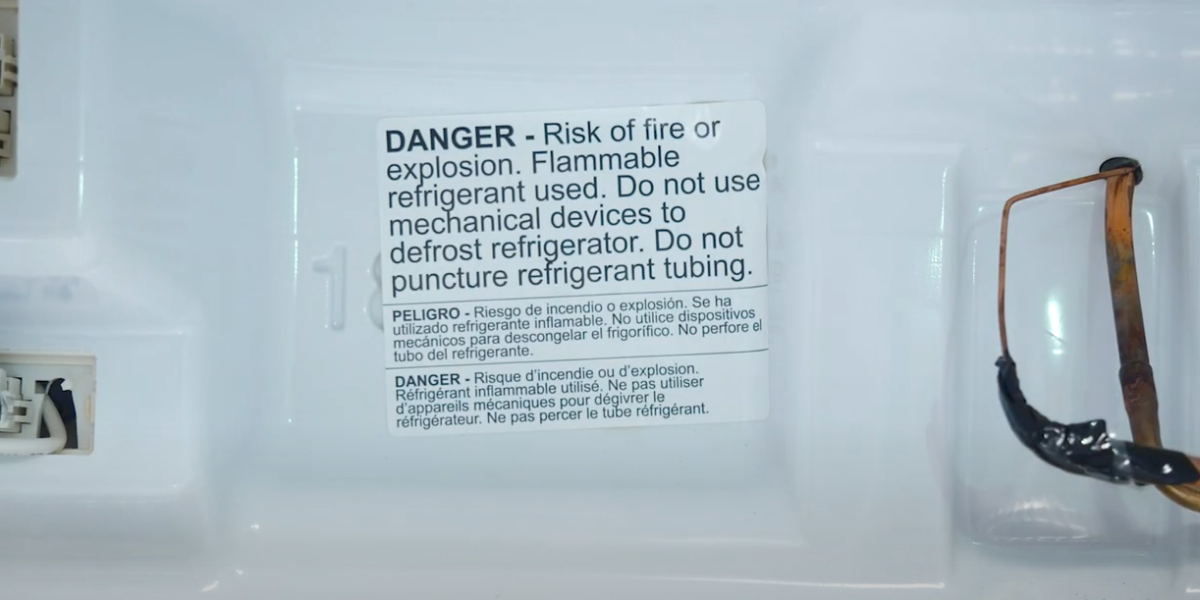 A warning lable inside of a fridge states that there is a risk for fire or explosion.