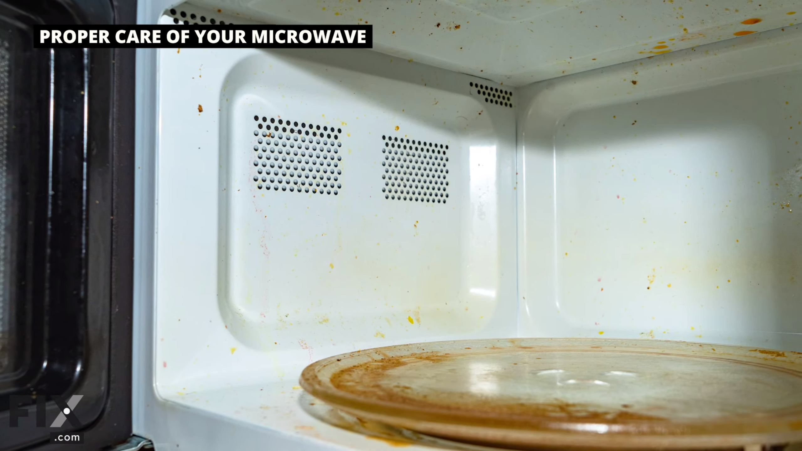 Interior of microwave with orange stained tray, and spatters on walls.
