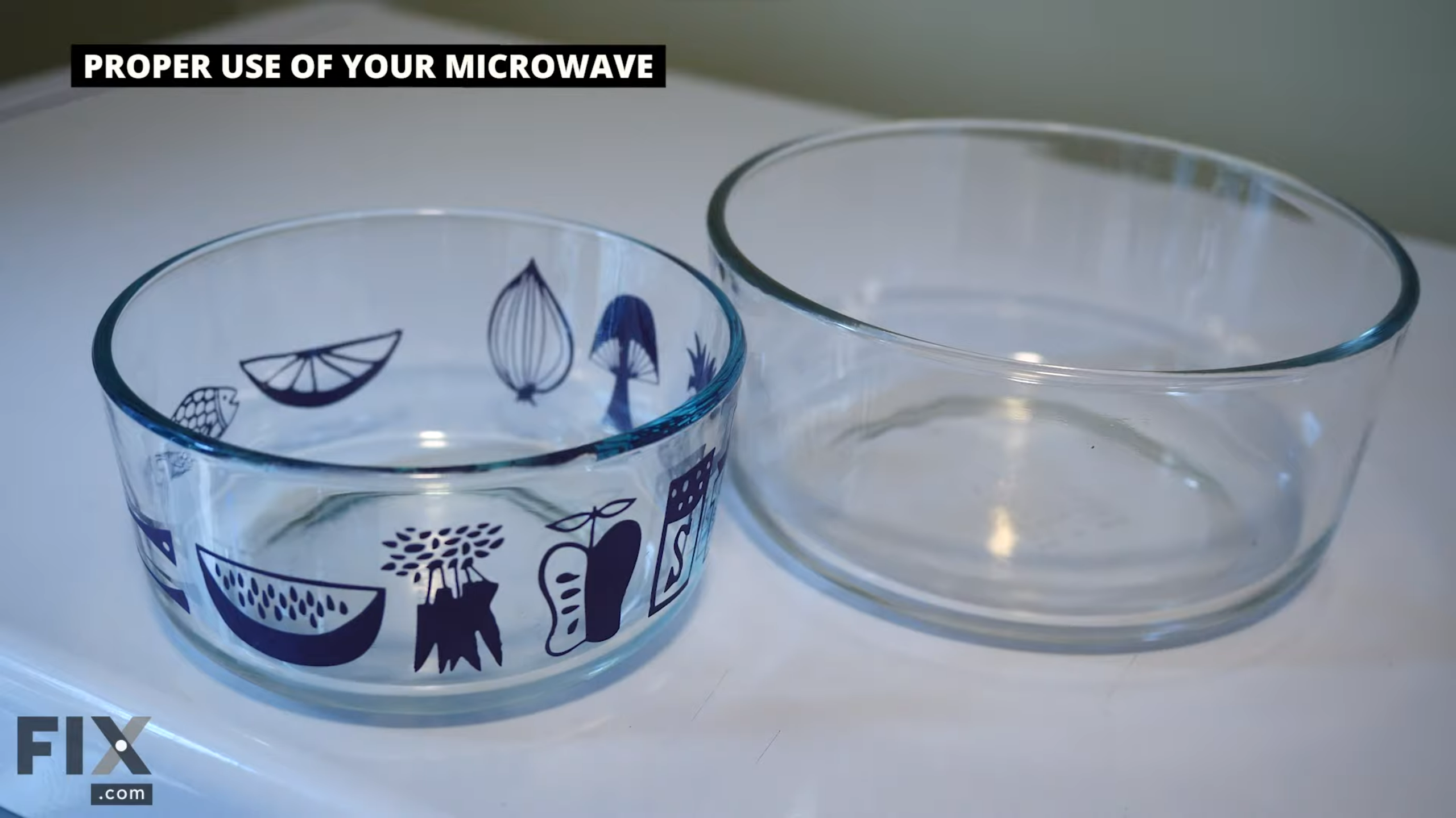 Two glass bowls without lids, one with a design and one without, sitting side-by-side on a white table.