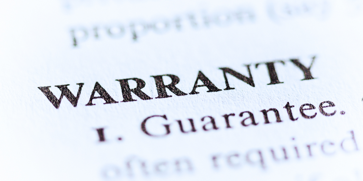 Close-up of a paper with printed text; 'Warranty' is in bold caps with 'Guarantee' below while surrounding words are blurred